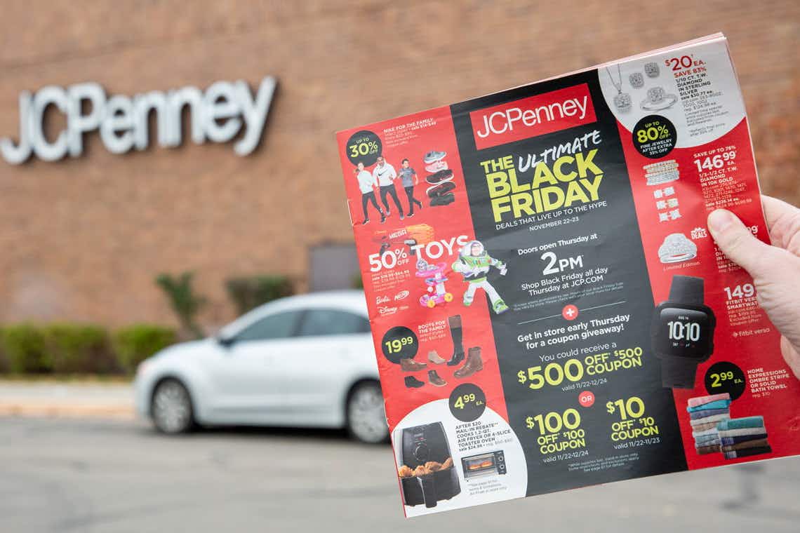 someone holding black friday ad in front of JCPenney