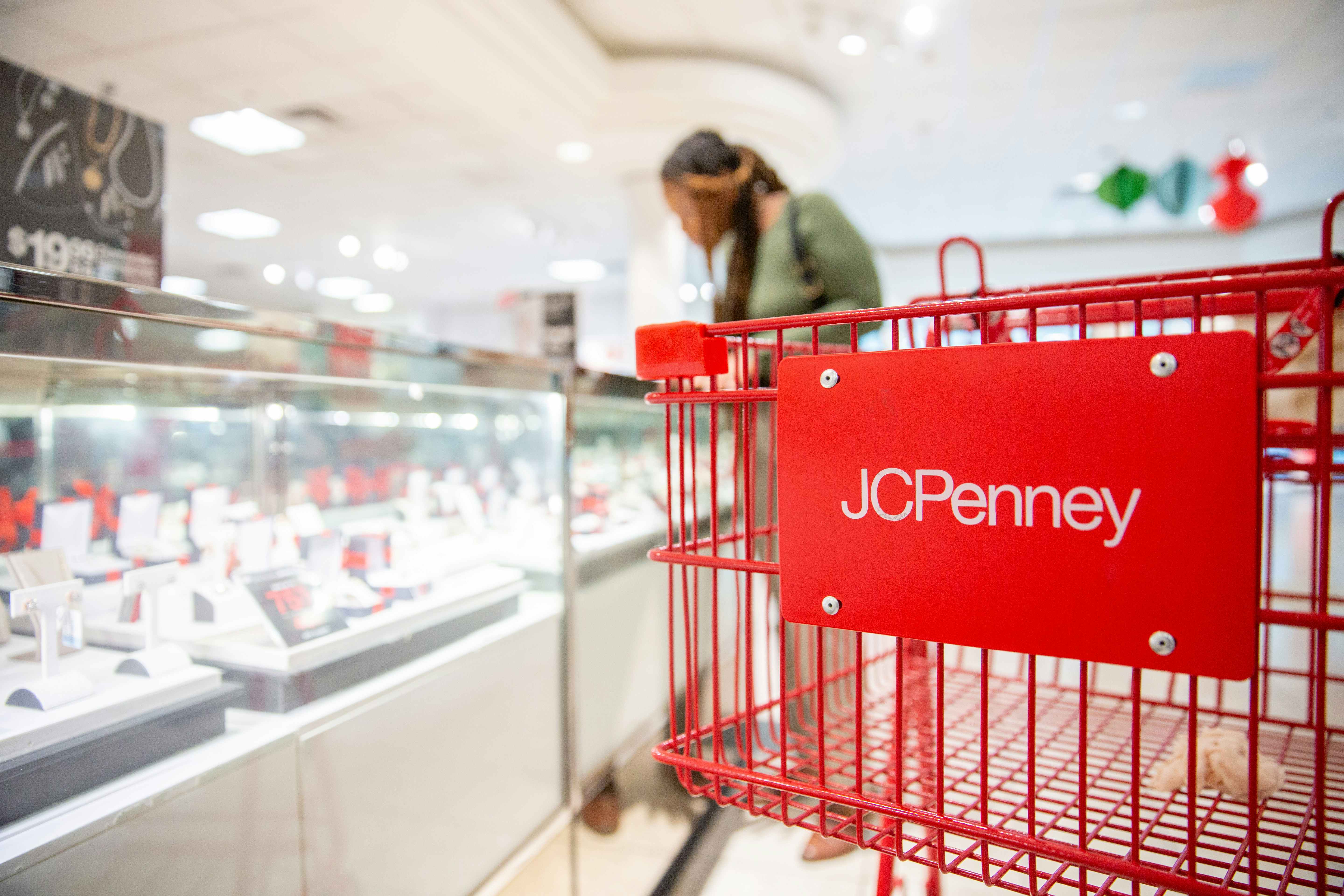 a woman shopping in jcpenney with a cart in the foreground