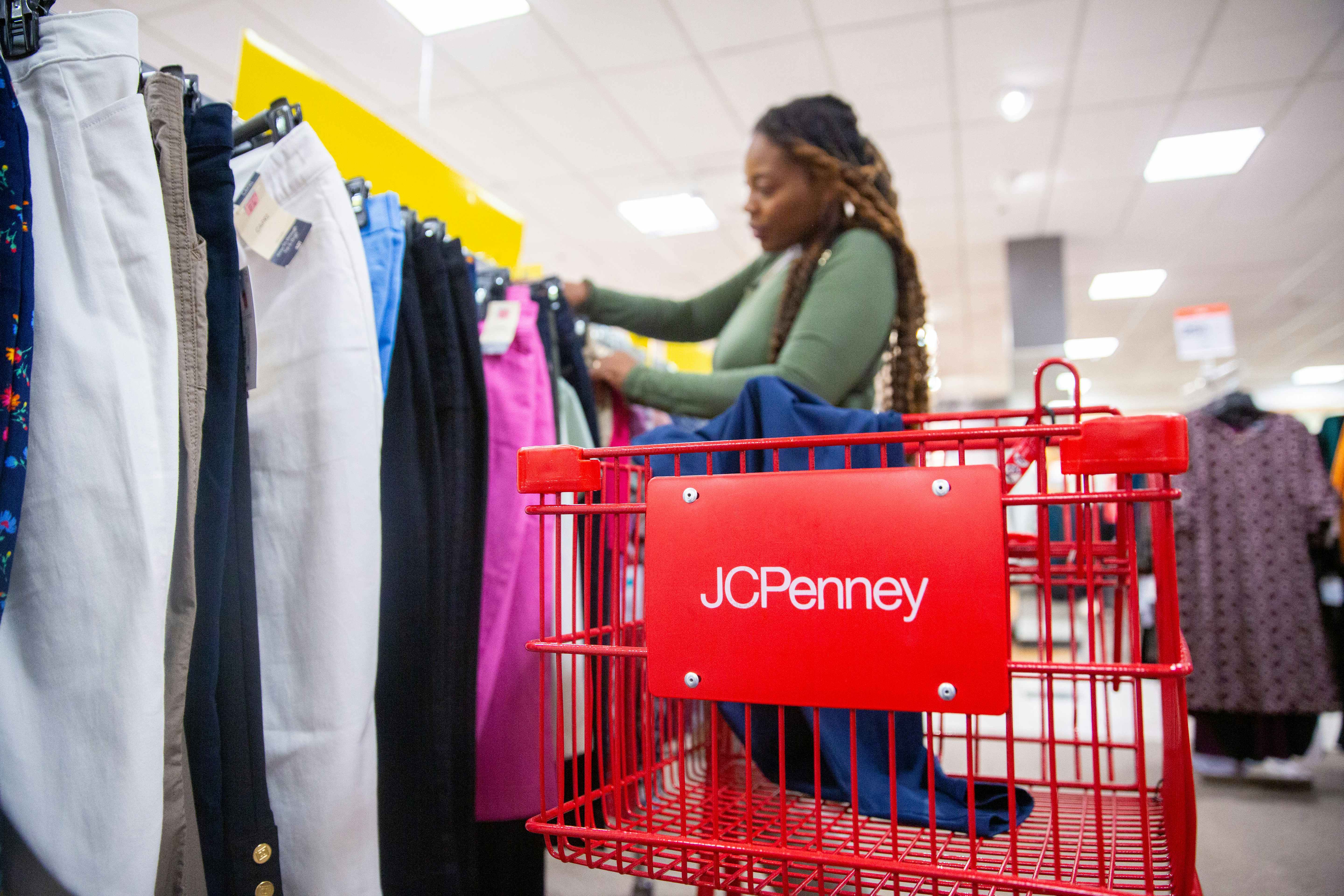 Person shopping with a red JC Penney's cart