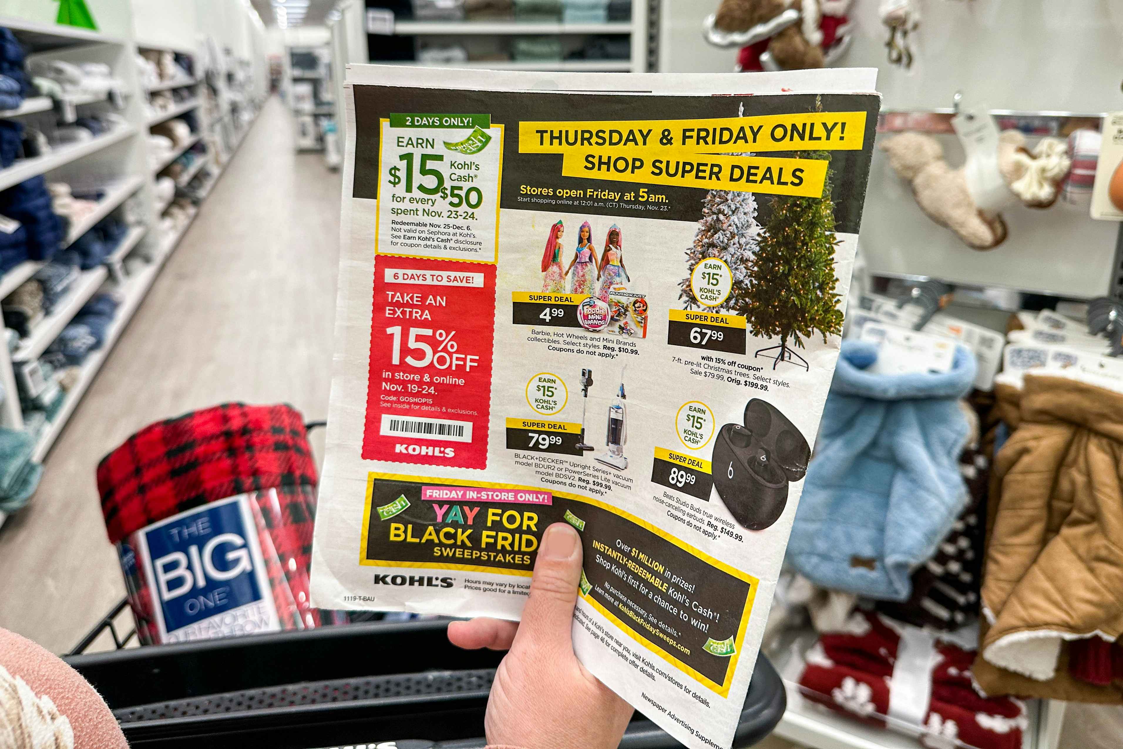 kohls black friday ad being held by cart 