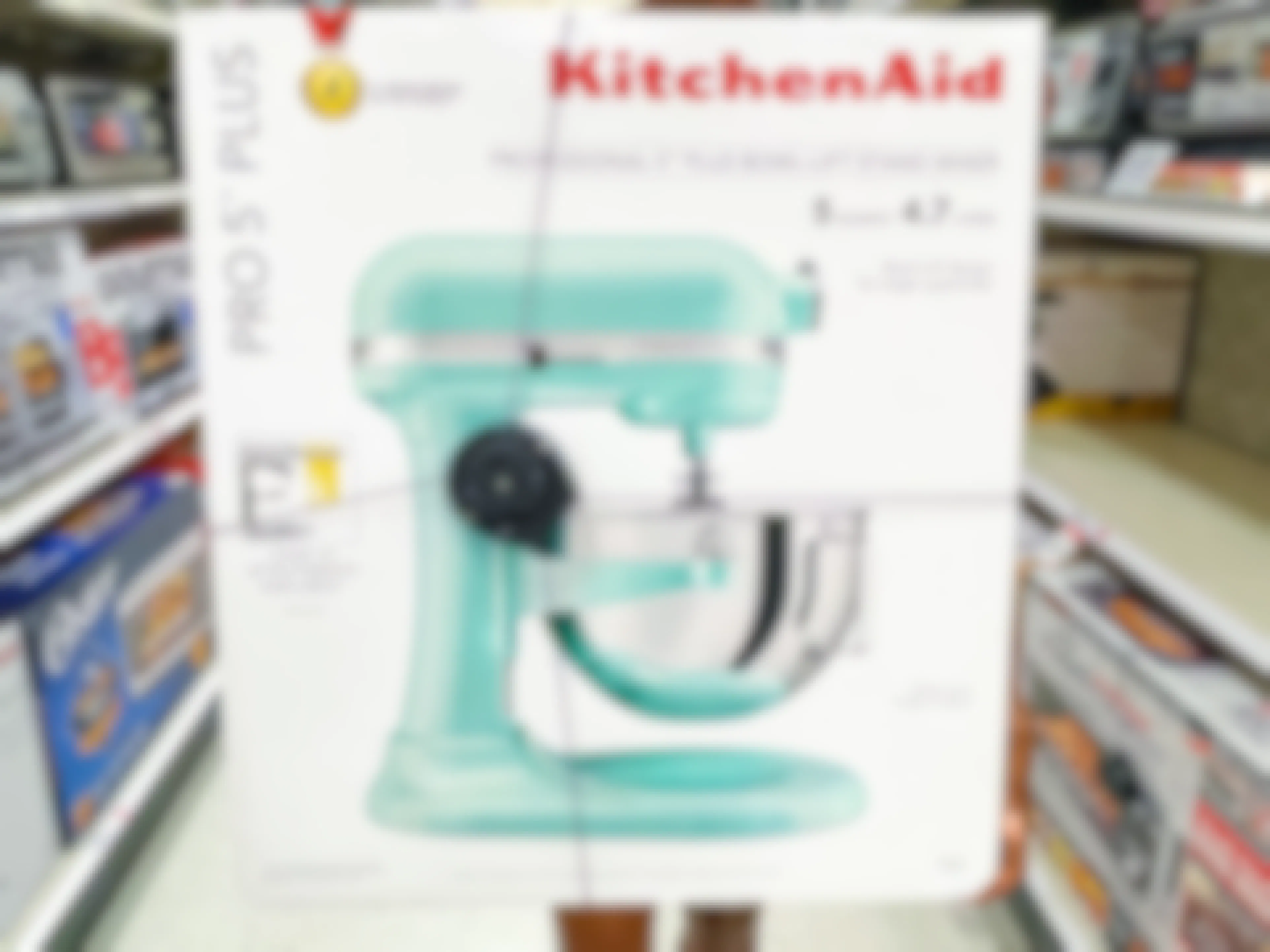 Someone holding a KitchenAid 5 quart stand mixer in an aisle at Target.