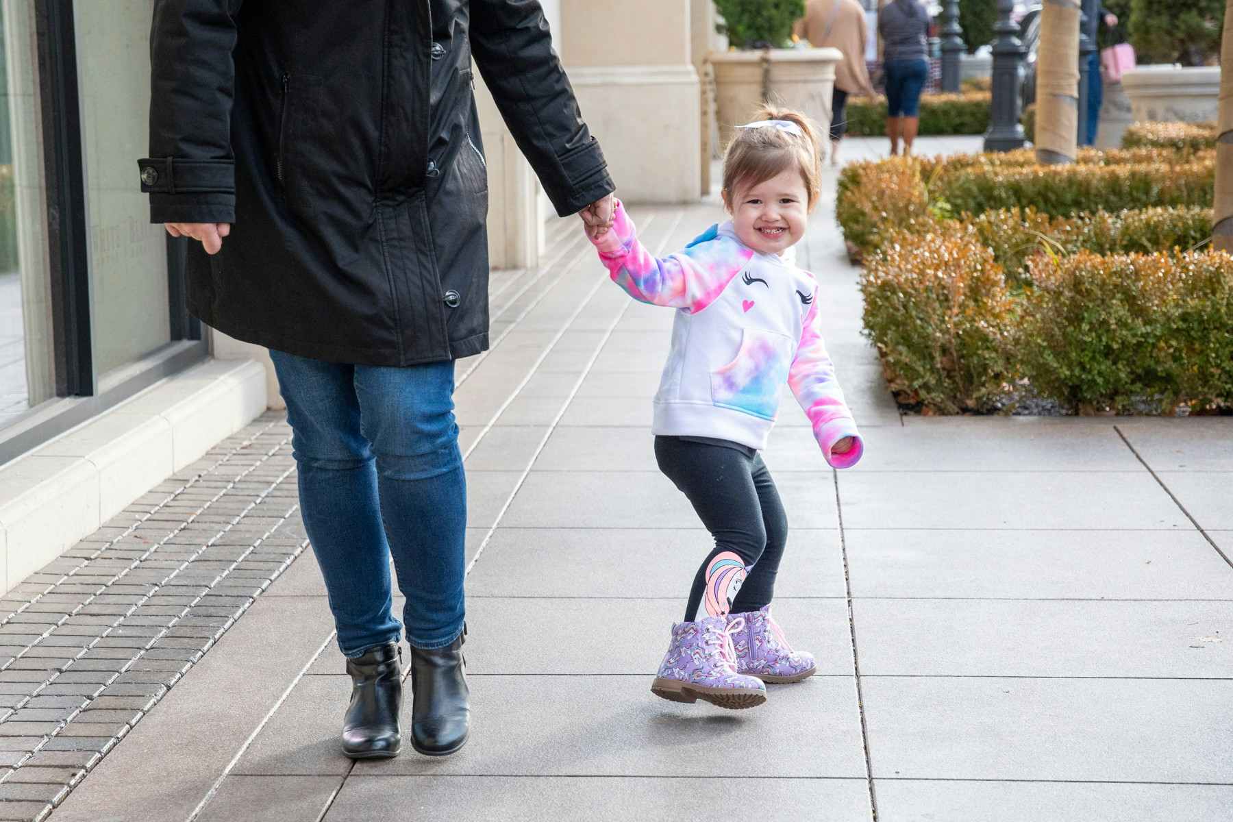 Toddler holding mom's hand smiling wearing unicorn outfit FabKids