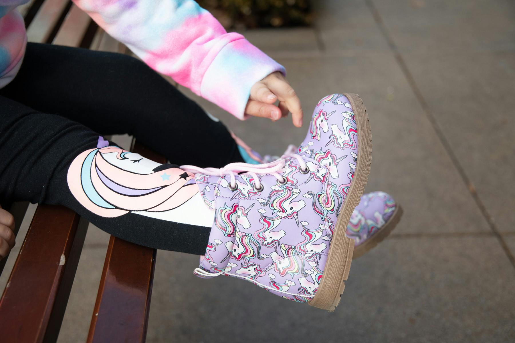 girl pointing to purple unicorn boots FabKids