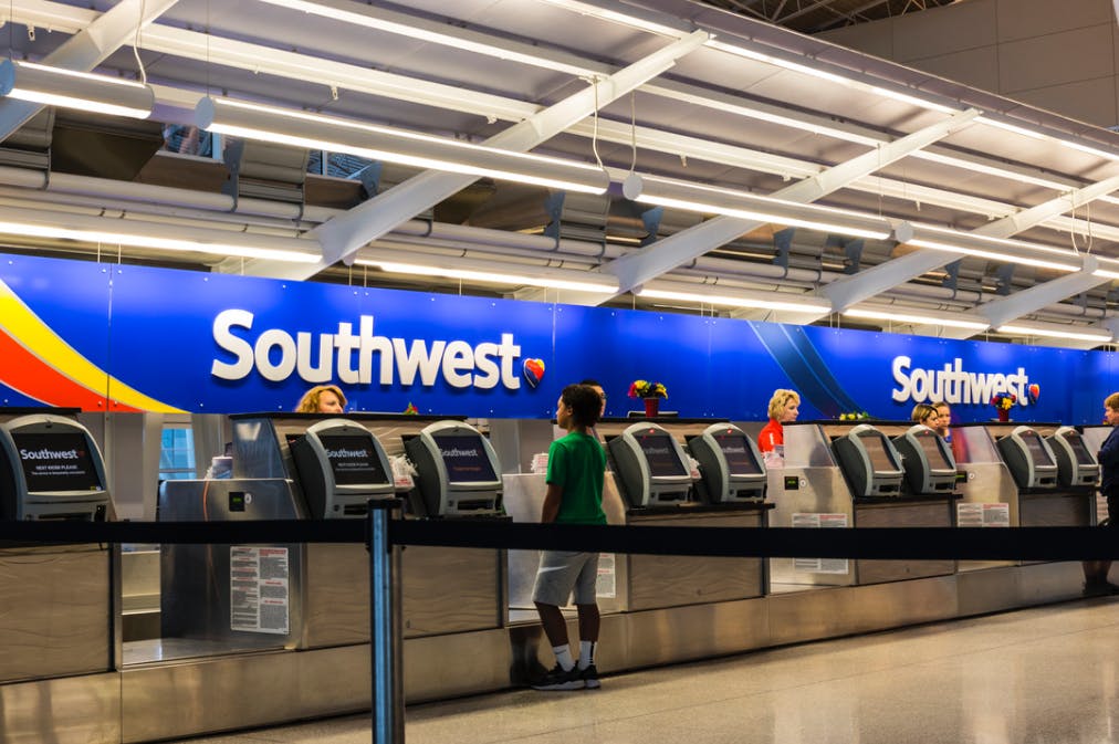 Person standing at Southwest Airlines ticket counter at airport.