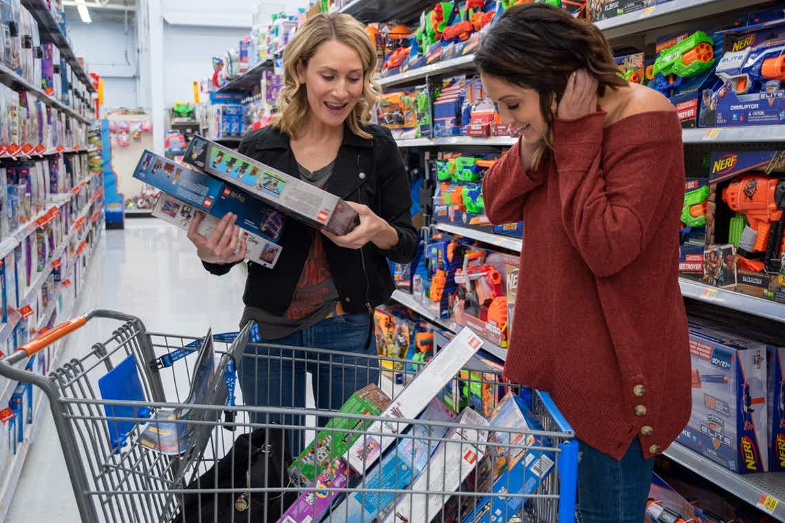 two women exclaim over toys and games in their walmart cart