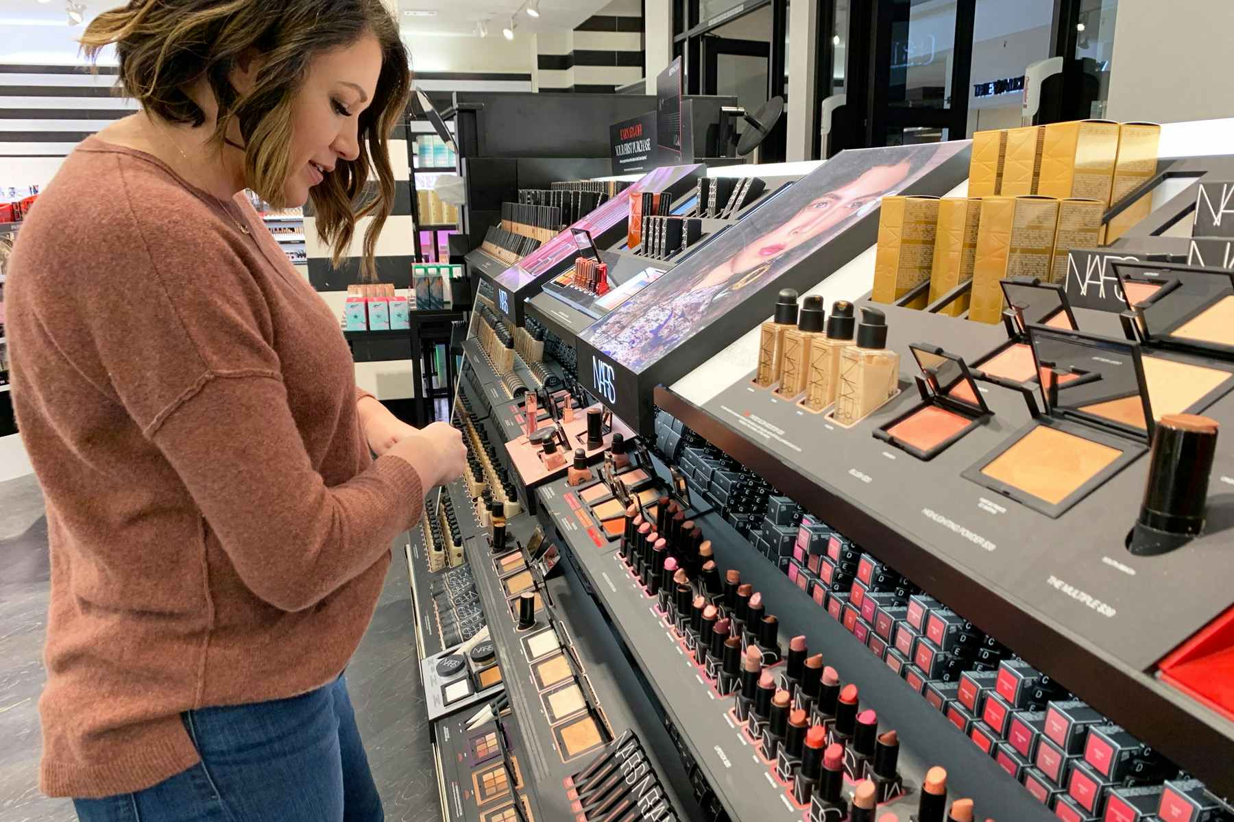 Woman looking at makeup in Sephora.