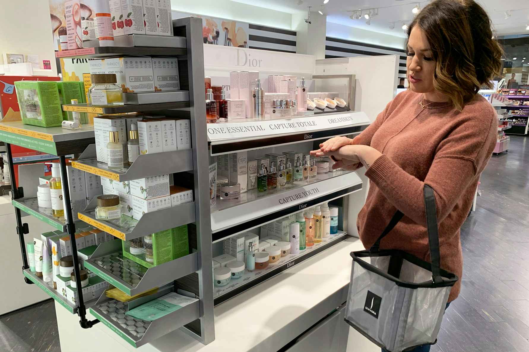 Woman trying Dior skin care from test container in Sephora.