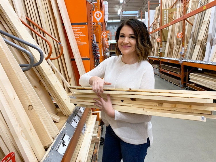 A woman with lumber in her arms.