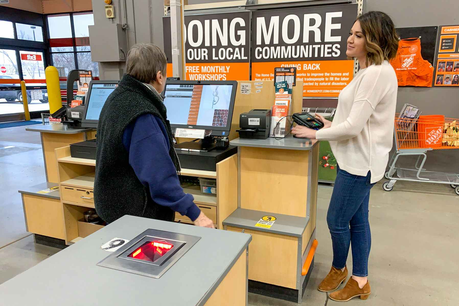 A woman and employee at the checkout register at the Home Depot.