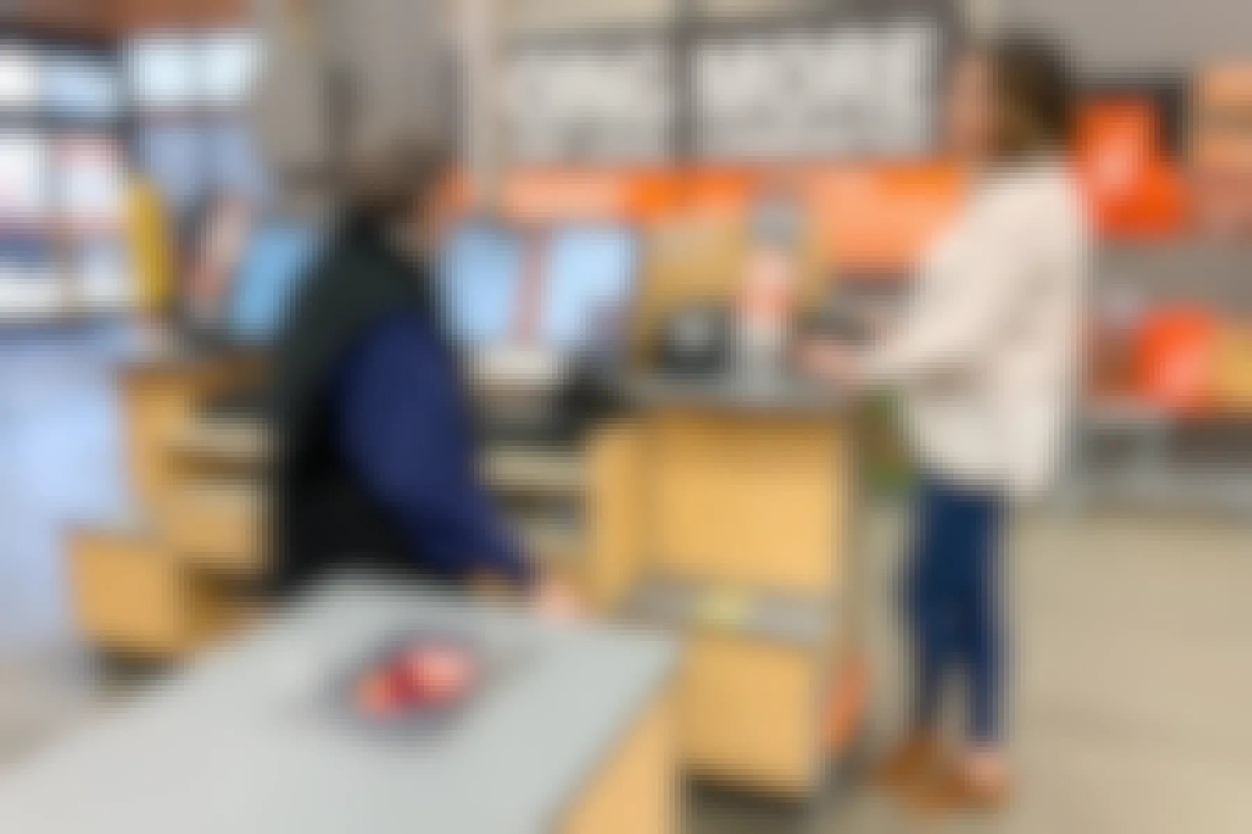 A woman and employee at the checkout register at the Home Depot.
