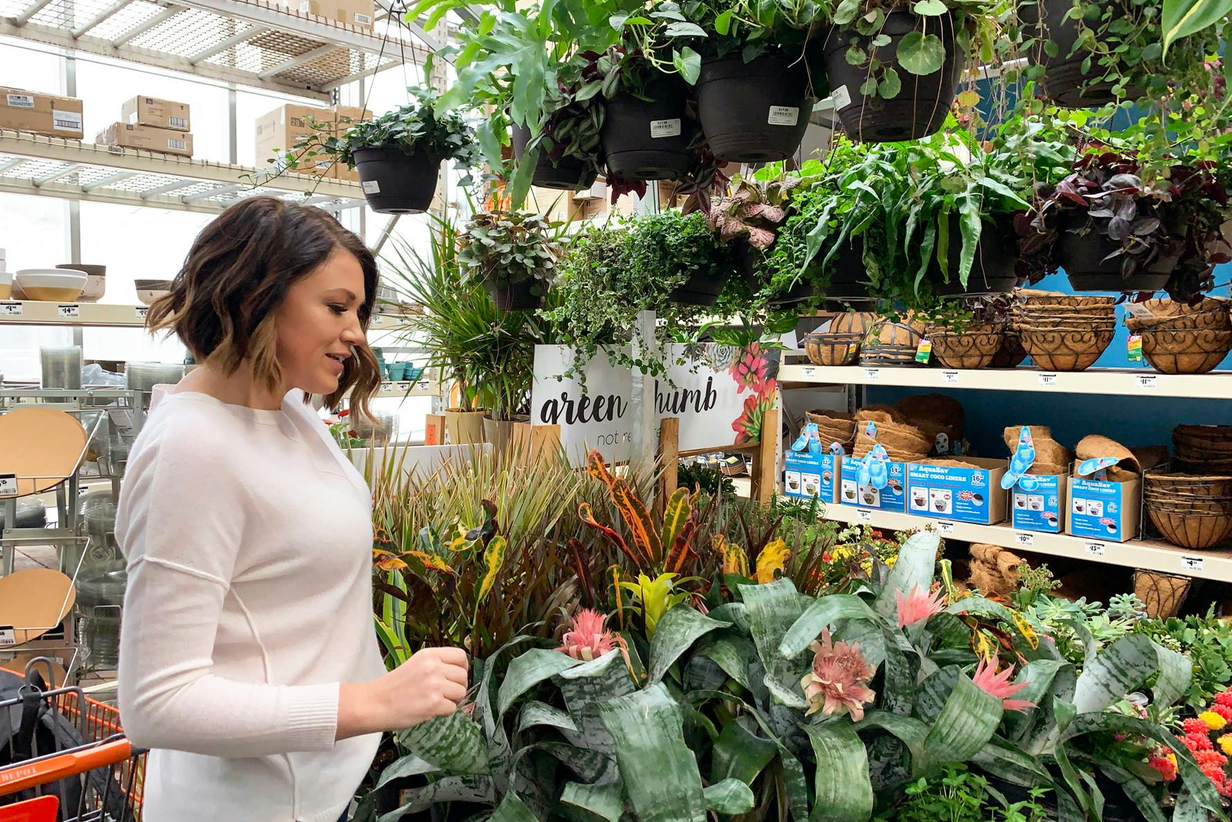 A woman looking at plants in the Home Depot garden center.