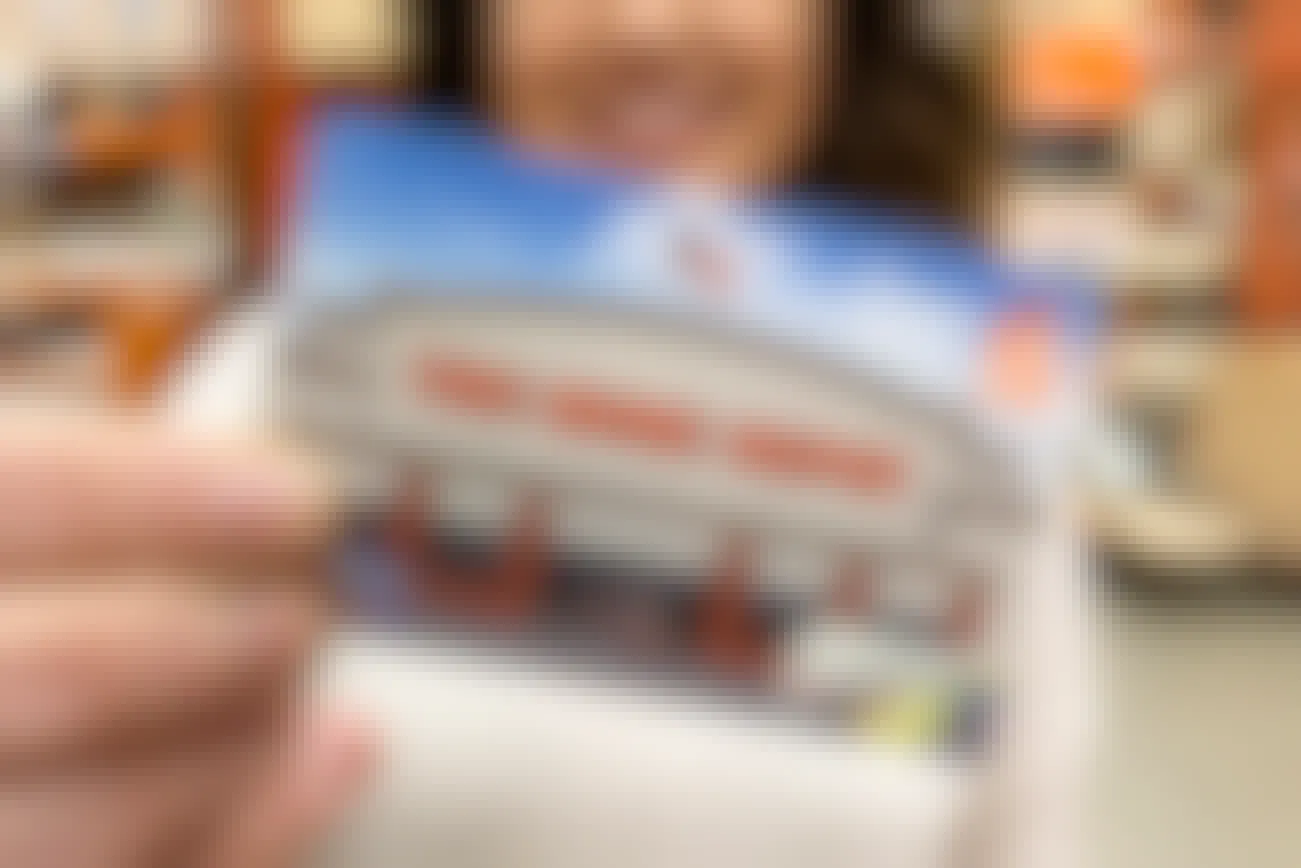 A woman holding a Home Depot gift card in front of her.