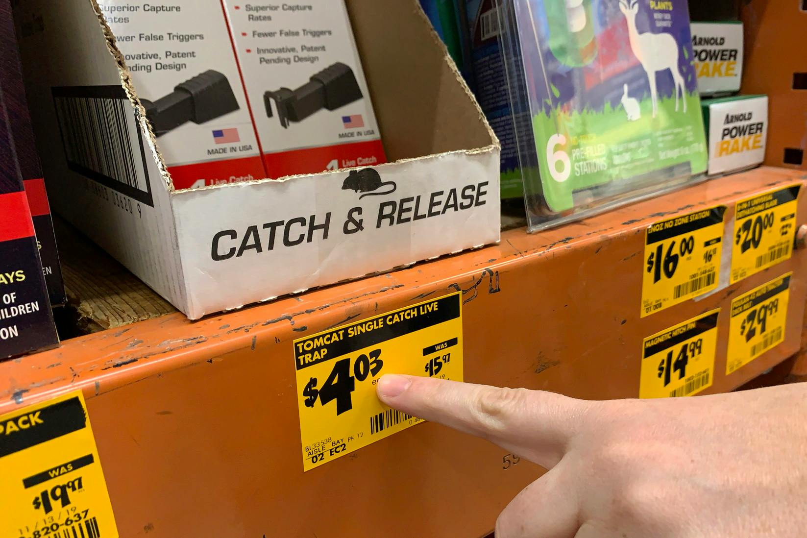 A hand pointing at a price tag ending in three.
