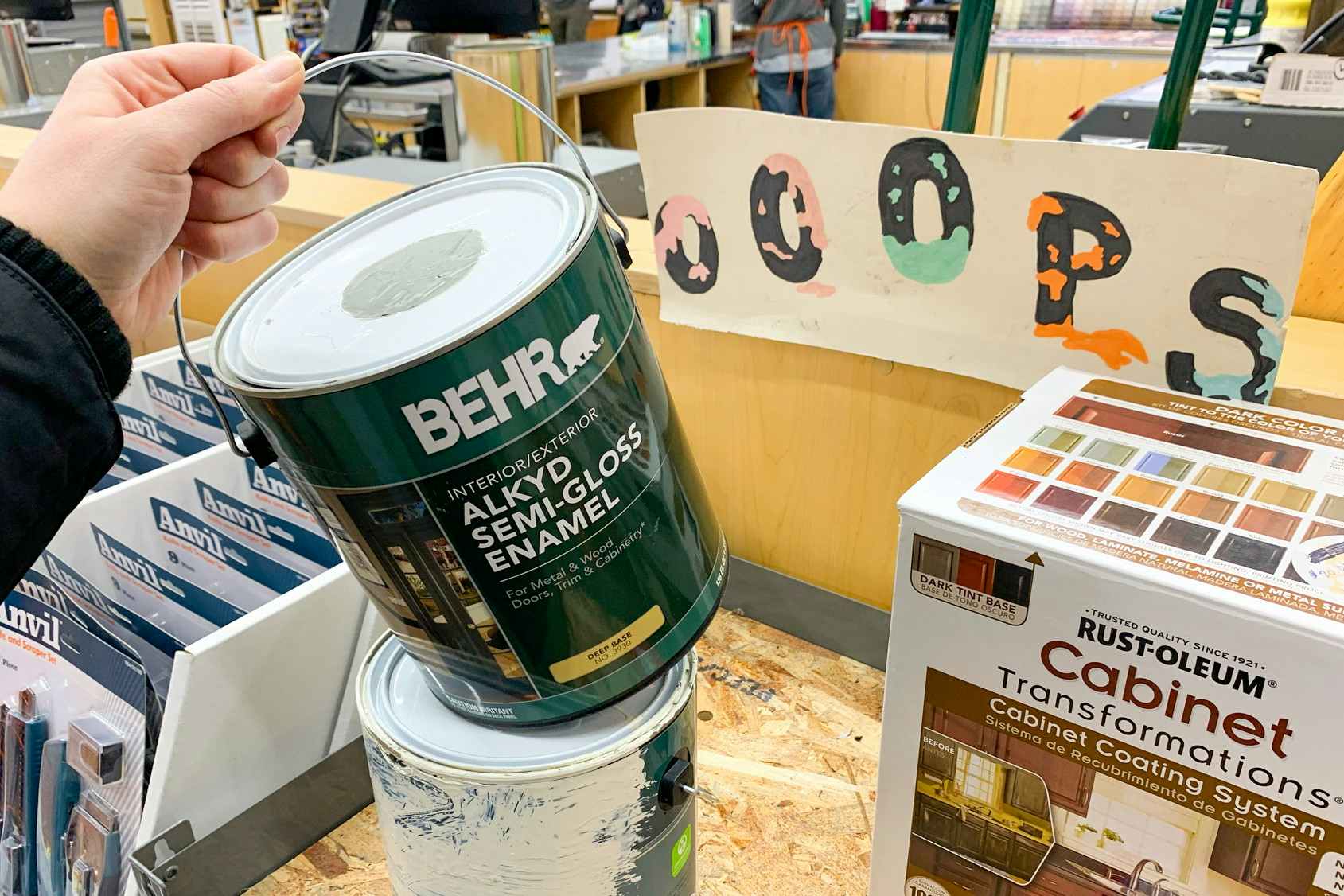 A person holding a gallon can of Behr paint