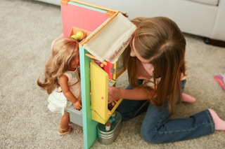 A girl plays with her American girl doll