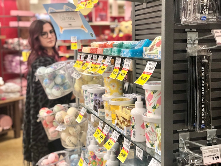 A woman passes the beauty aisle with her cart.
