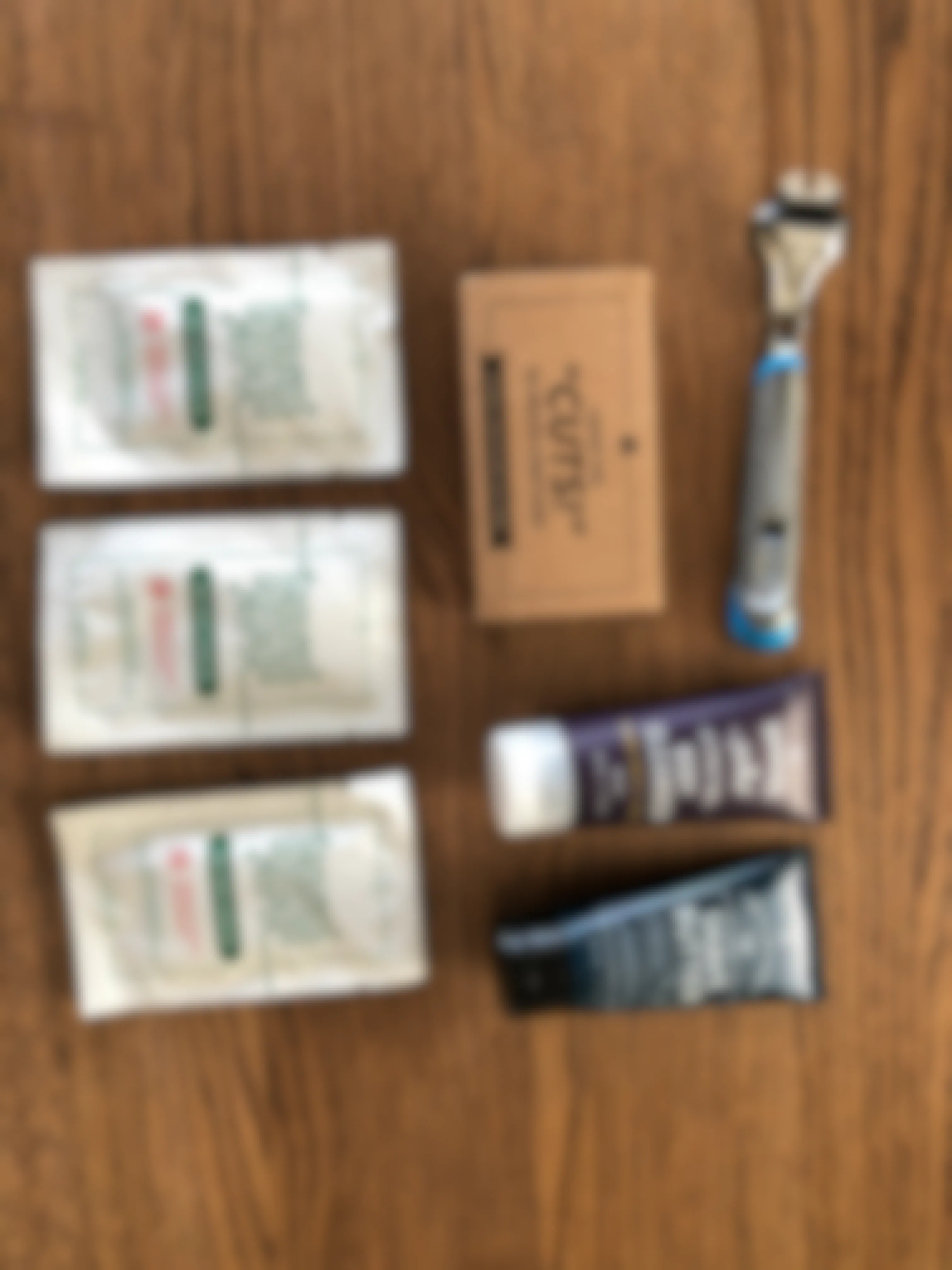 Dollar Shave Club's starter set box contents laid out on a table, including handle, wipes, shaving foam and face cleanser