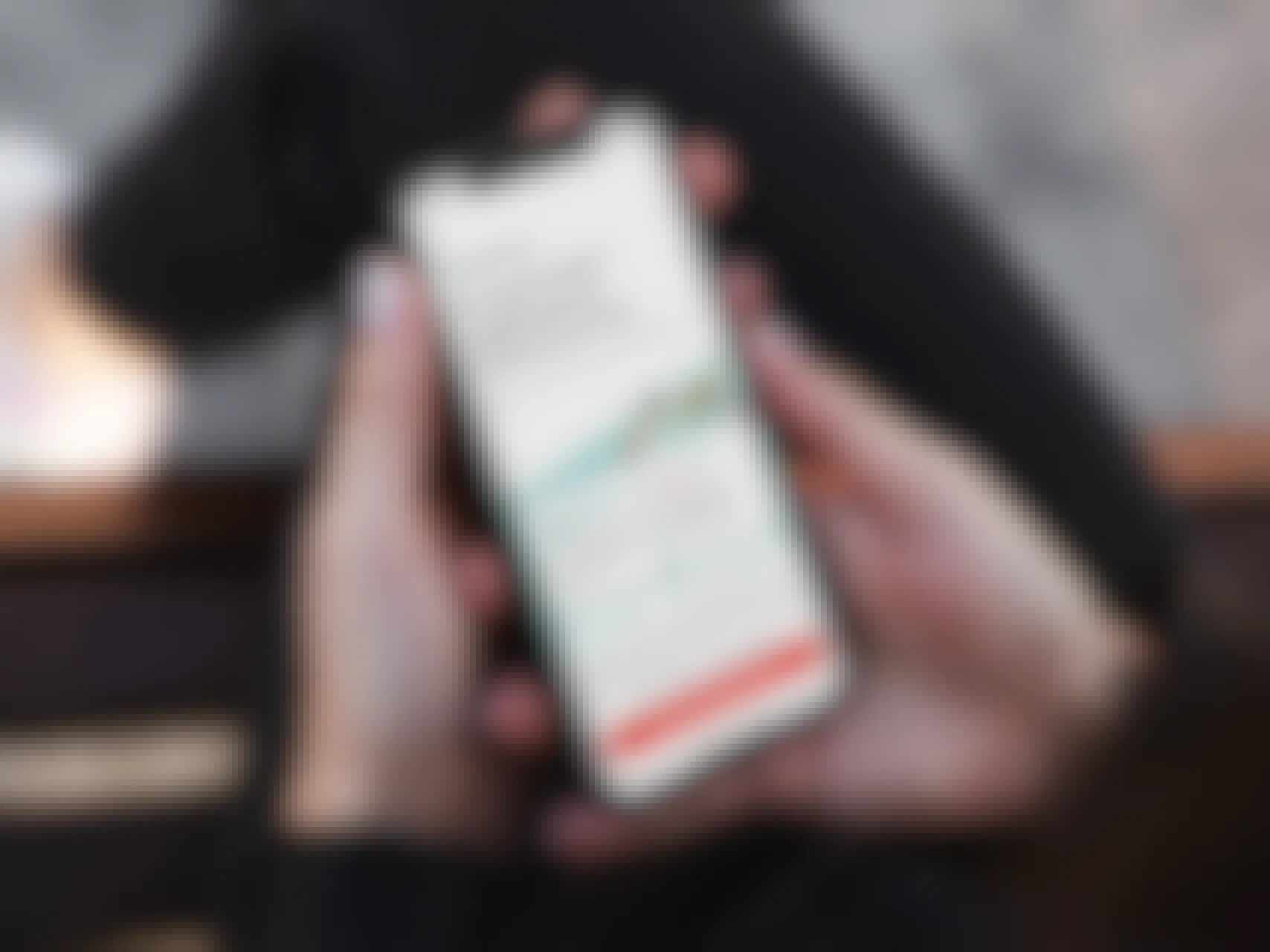 someone holding a phone displaying the app page for DoorDash Dash Pass