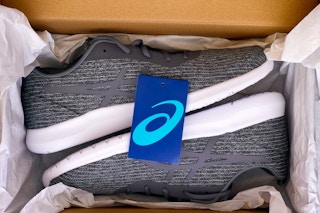 New gray Asics running shoes in box.