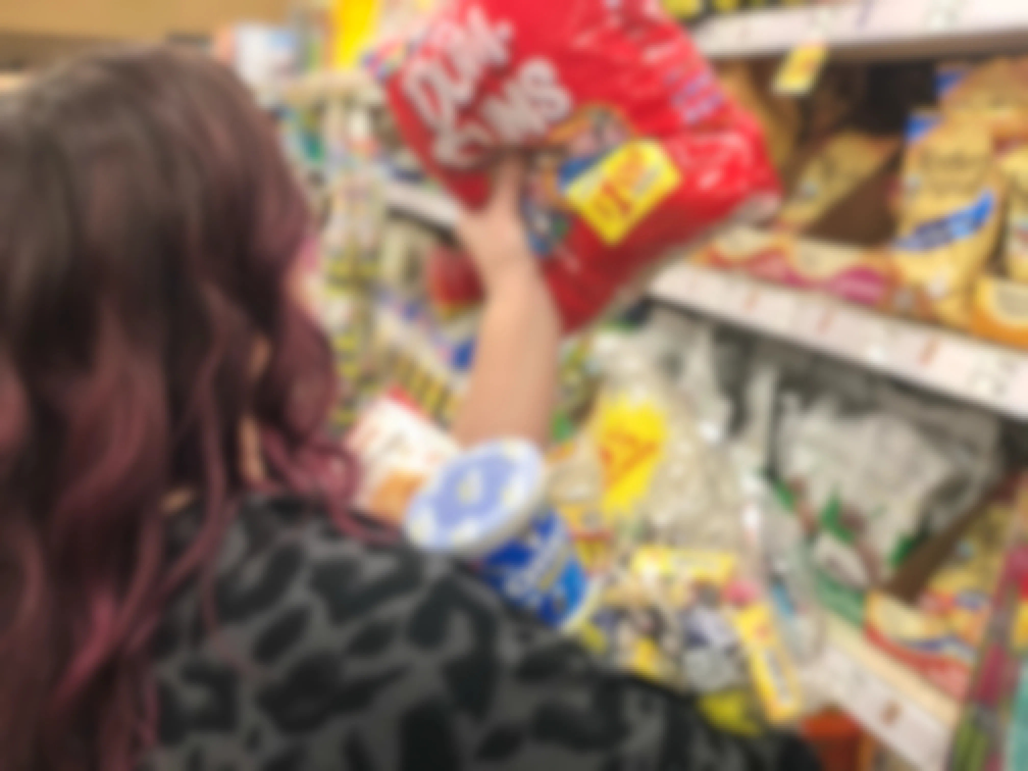 A woman grabs armfuls of candy.