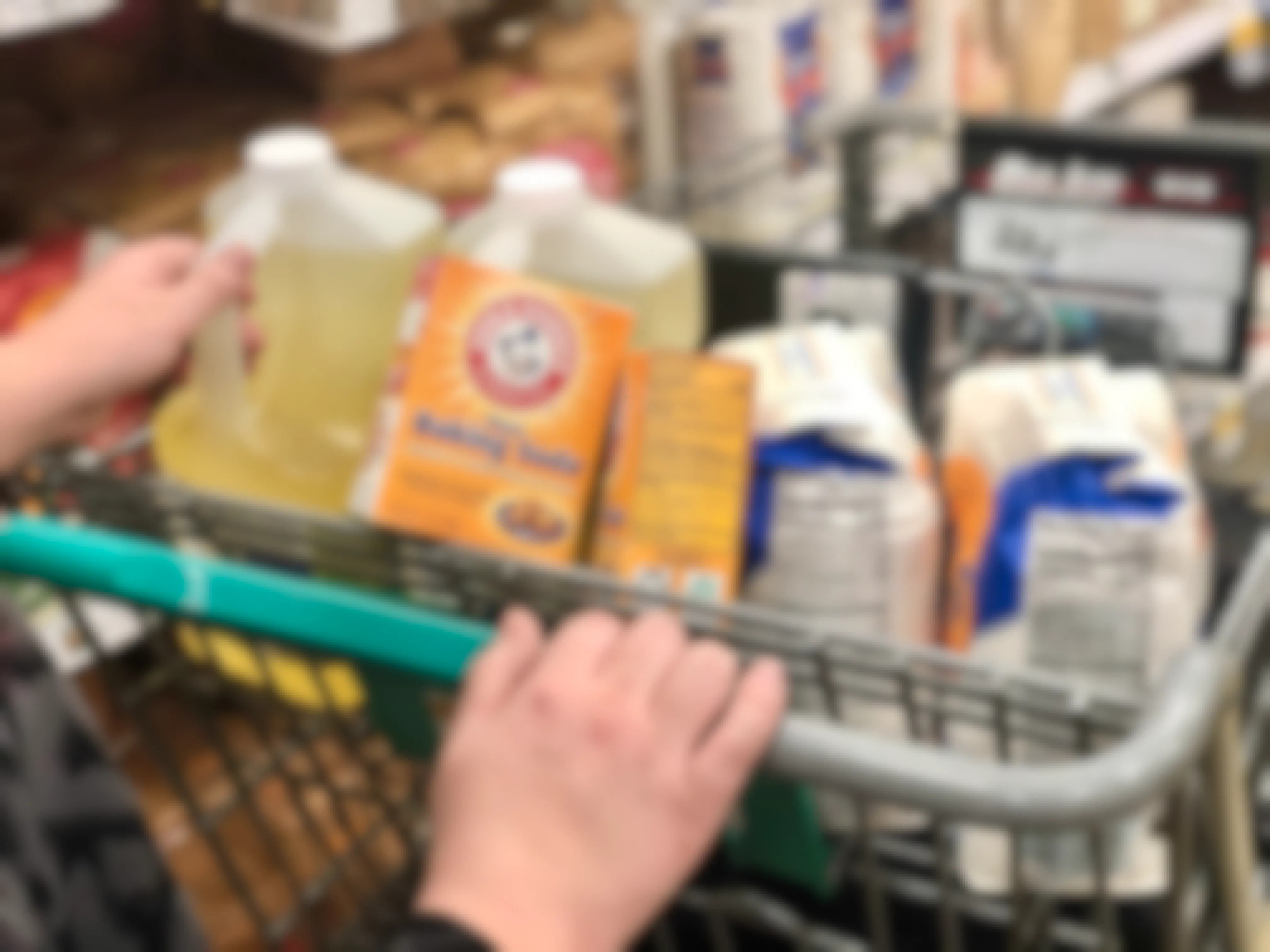 A woman has a cart full of pantry items.