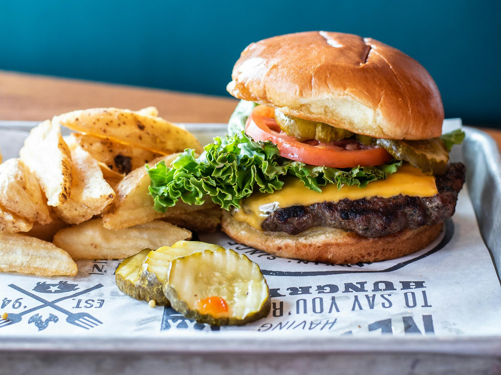 A tray from Famous Dave's with a large cheeseburger and fries