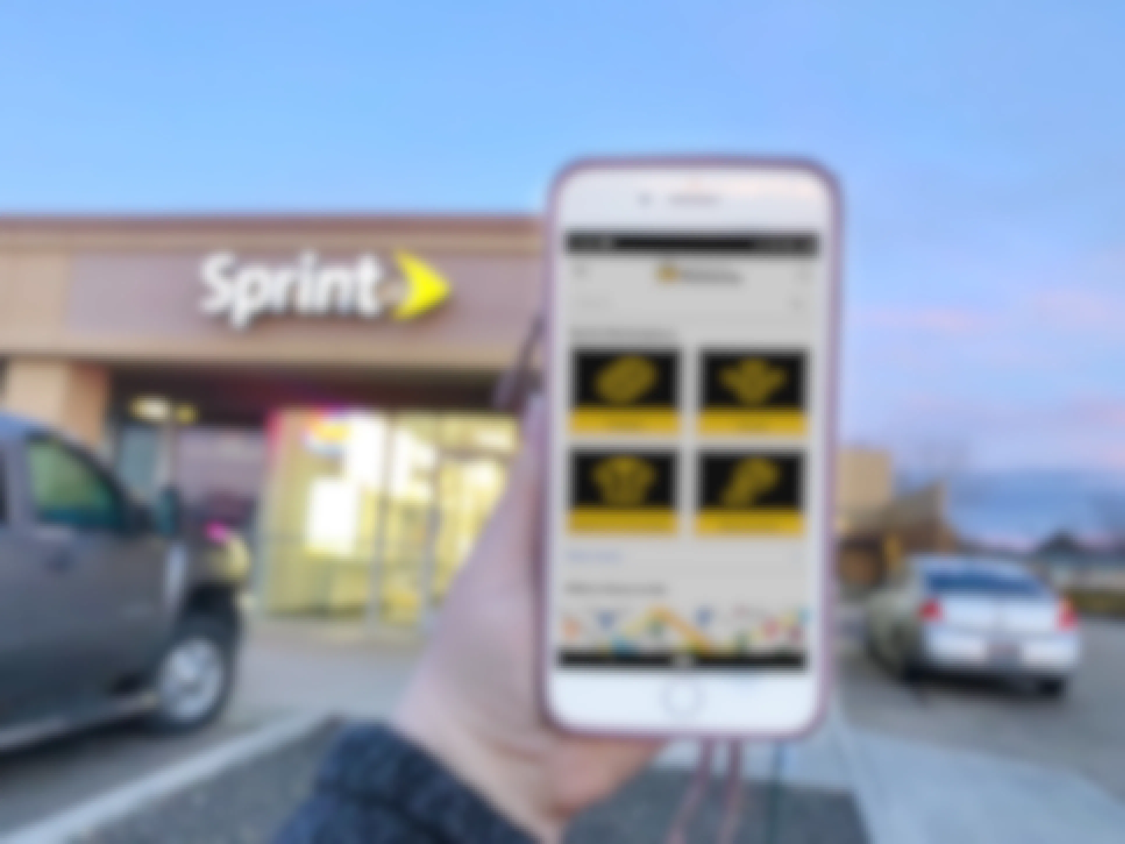 a phone with Sprint rewards on the screen and a spring store in the background.
