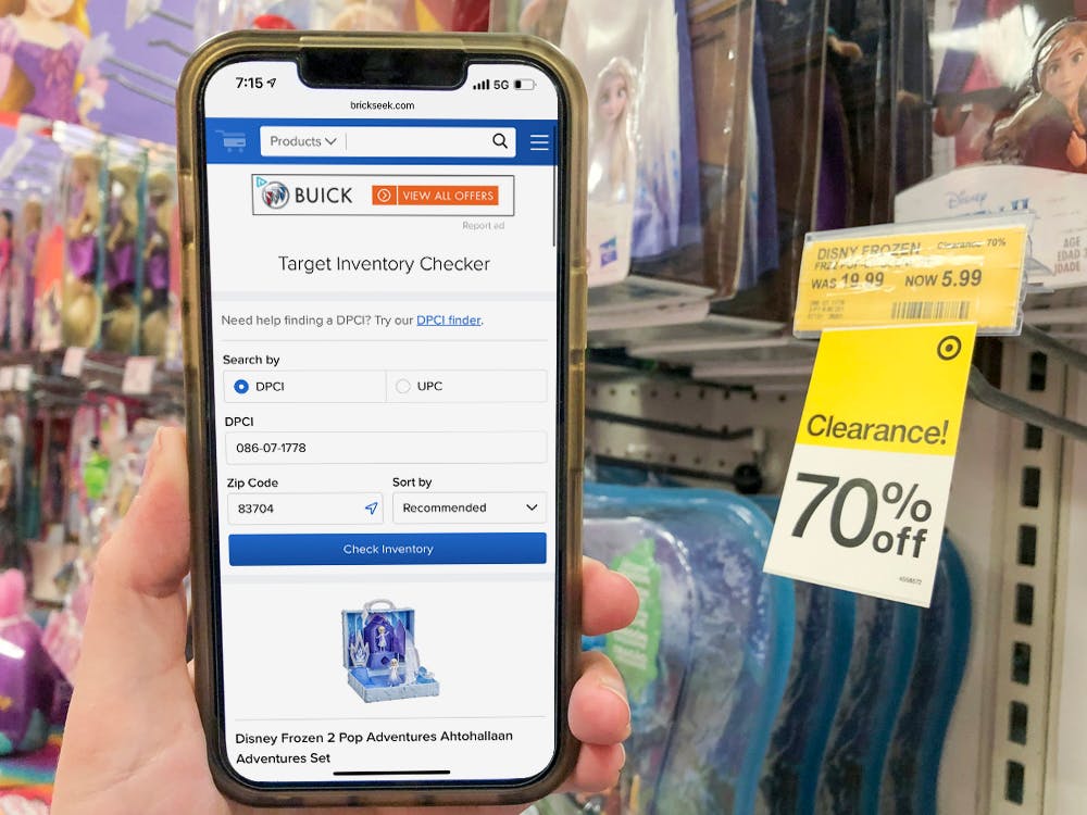 Brickseek.com open on a cell phone, held next to a 70% off clearance sticker in the Target toy aisle