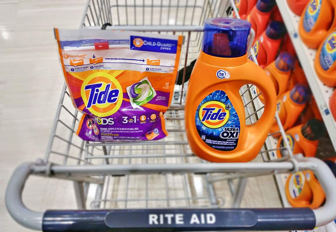 Tide Pods and a bottle of Tide detergent sitting in a Rite Aid cart.