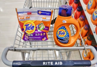 Tide Pods and a bottle of Tide detergent sitting in a Rite Aid cart.