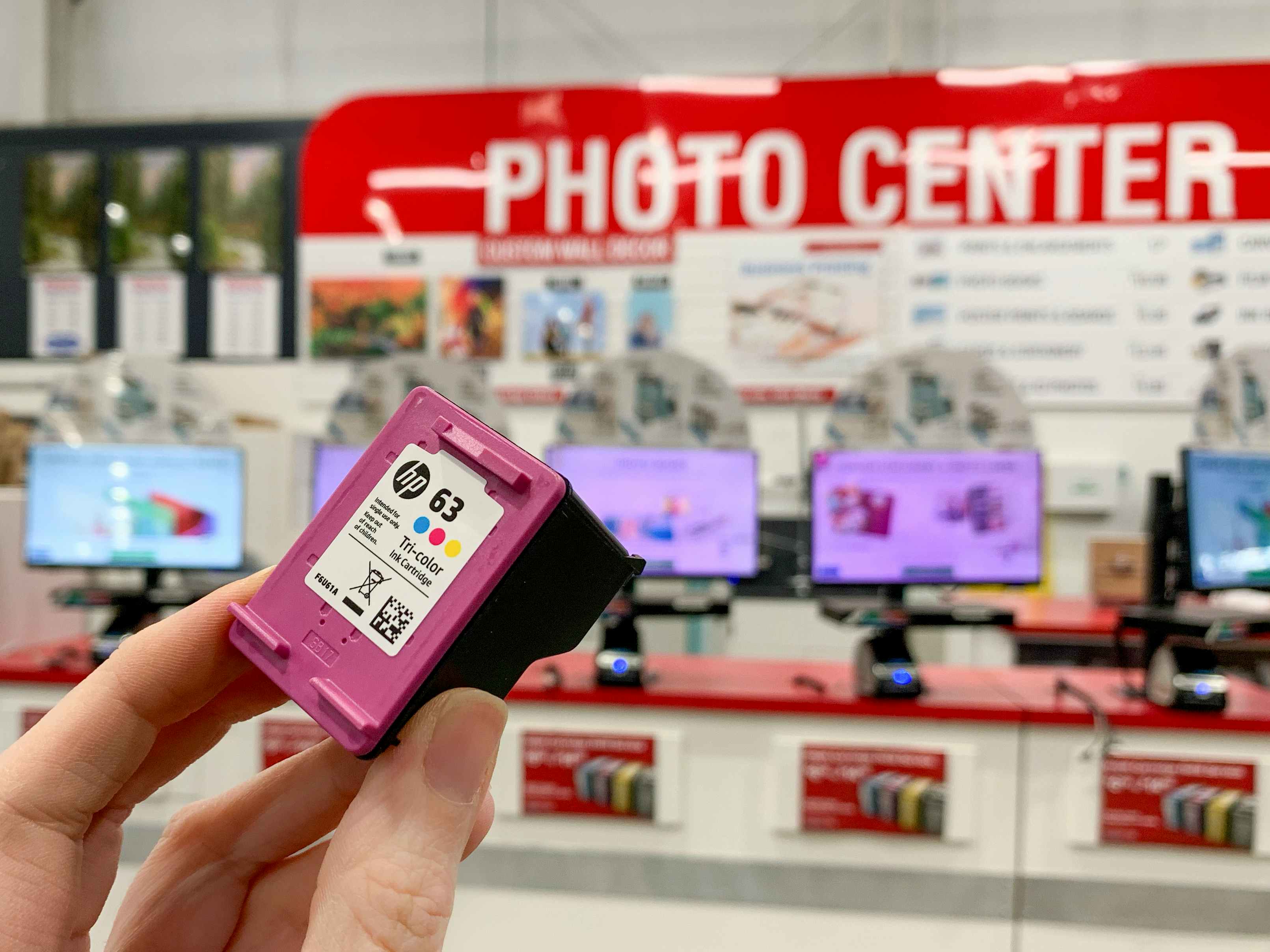 An HP ink cartridge held in front of the Costco photo center.