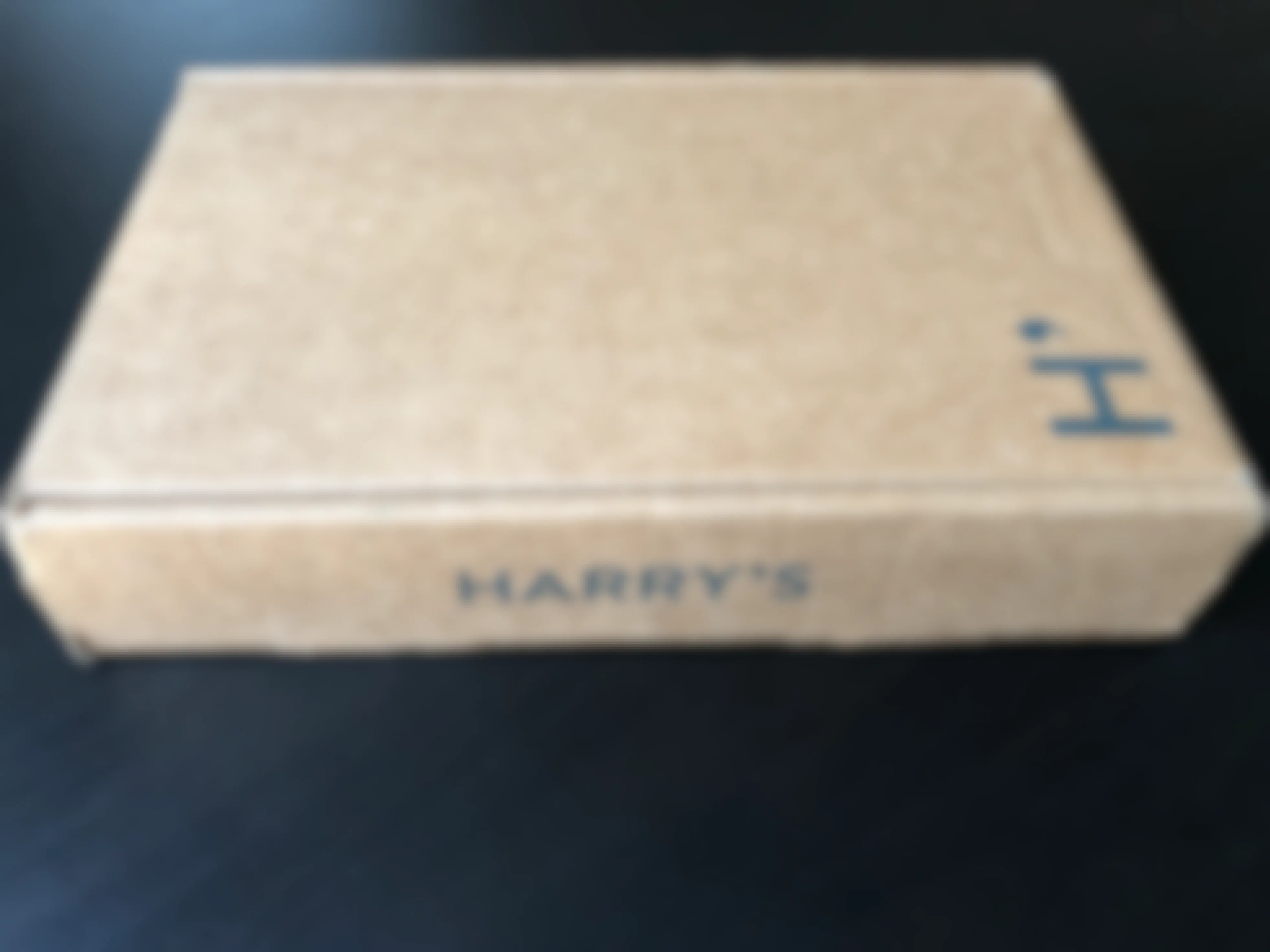 Harry's starter kit box unopened on a black table.
