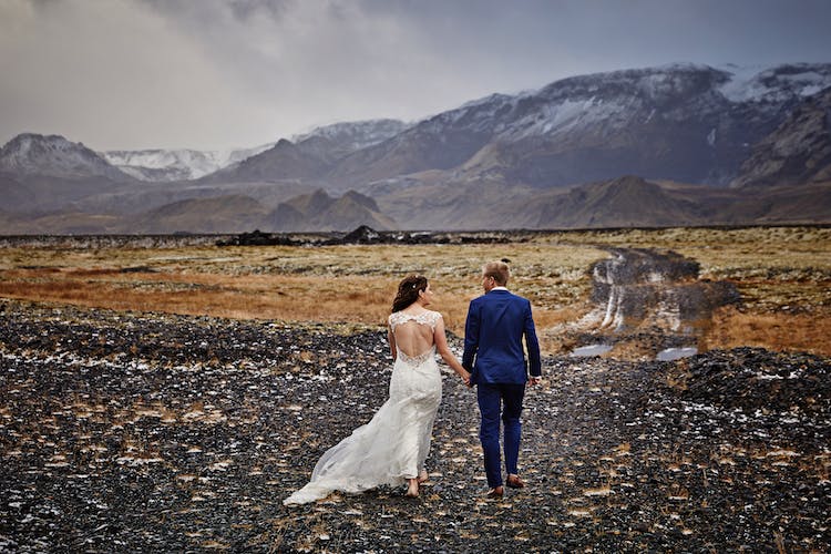 A couple walks in the Icelandic landscape on their wedding day