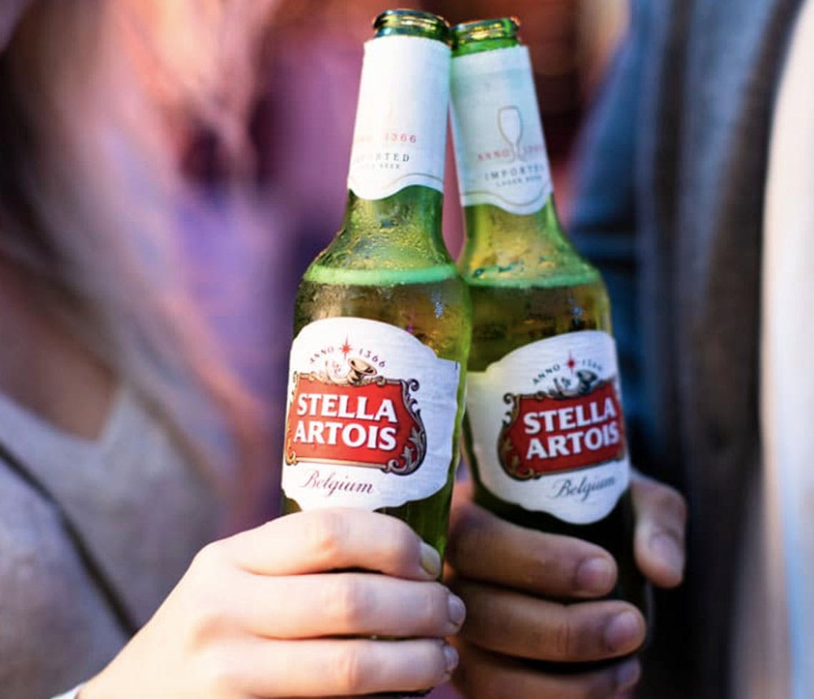 two hands tapping stella-artois in cheers