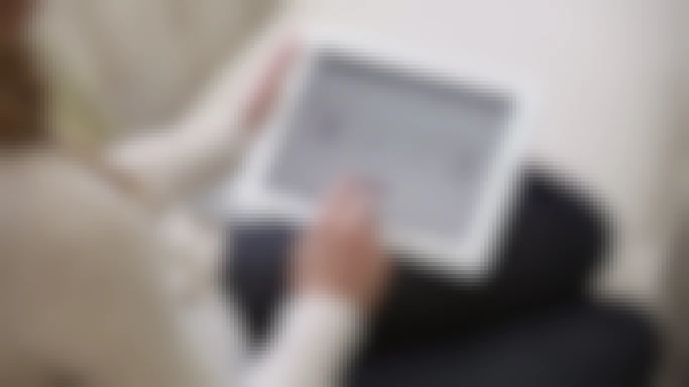 A person adjusting their thermostat settings using a tablet.