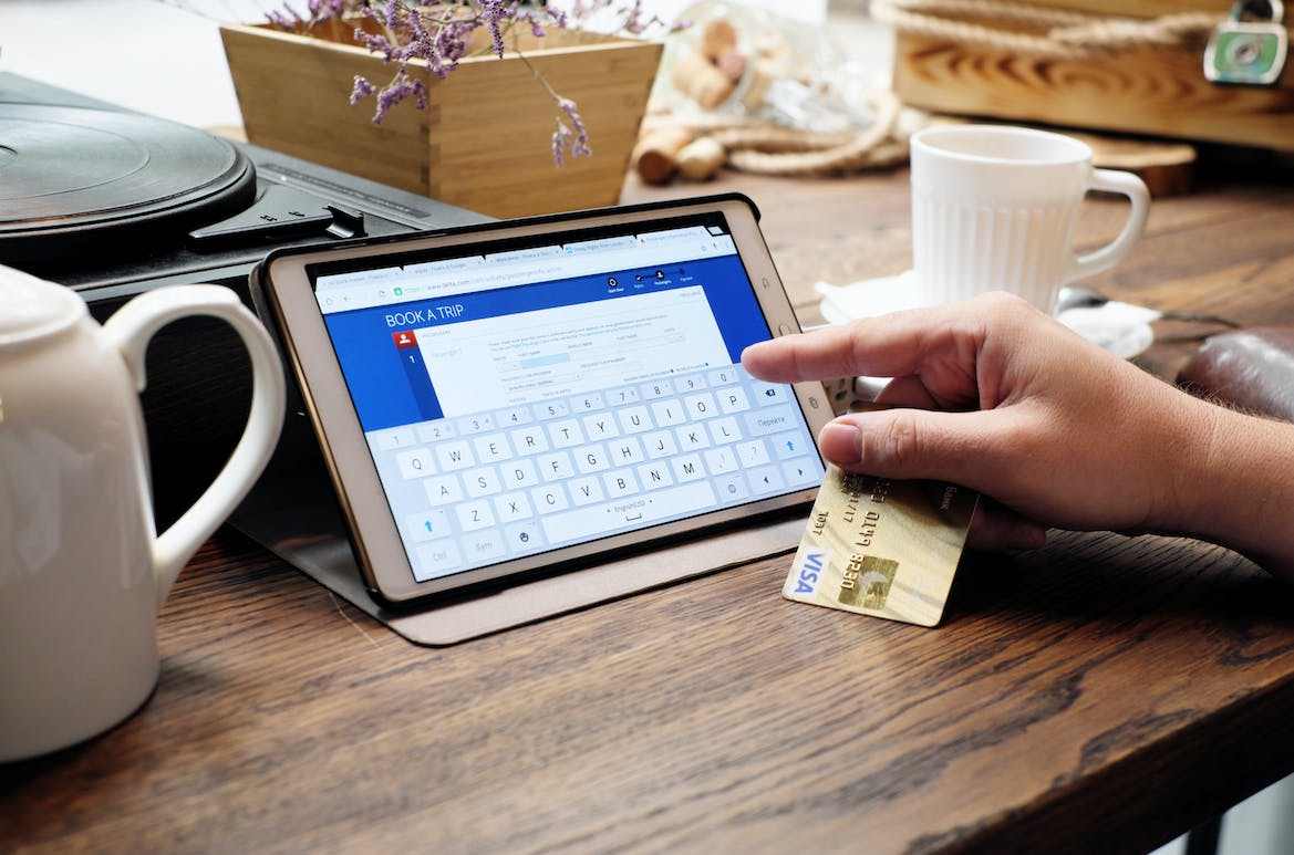 Someone holding a Chase card while purchasing something on their tablet