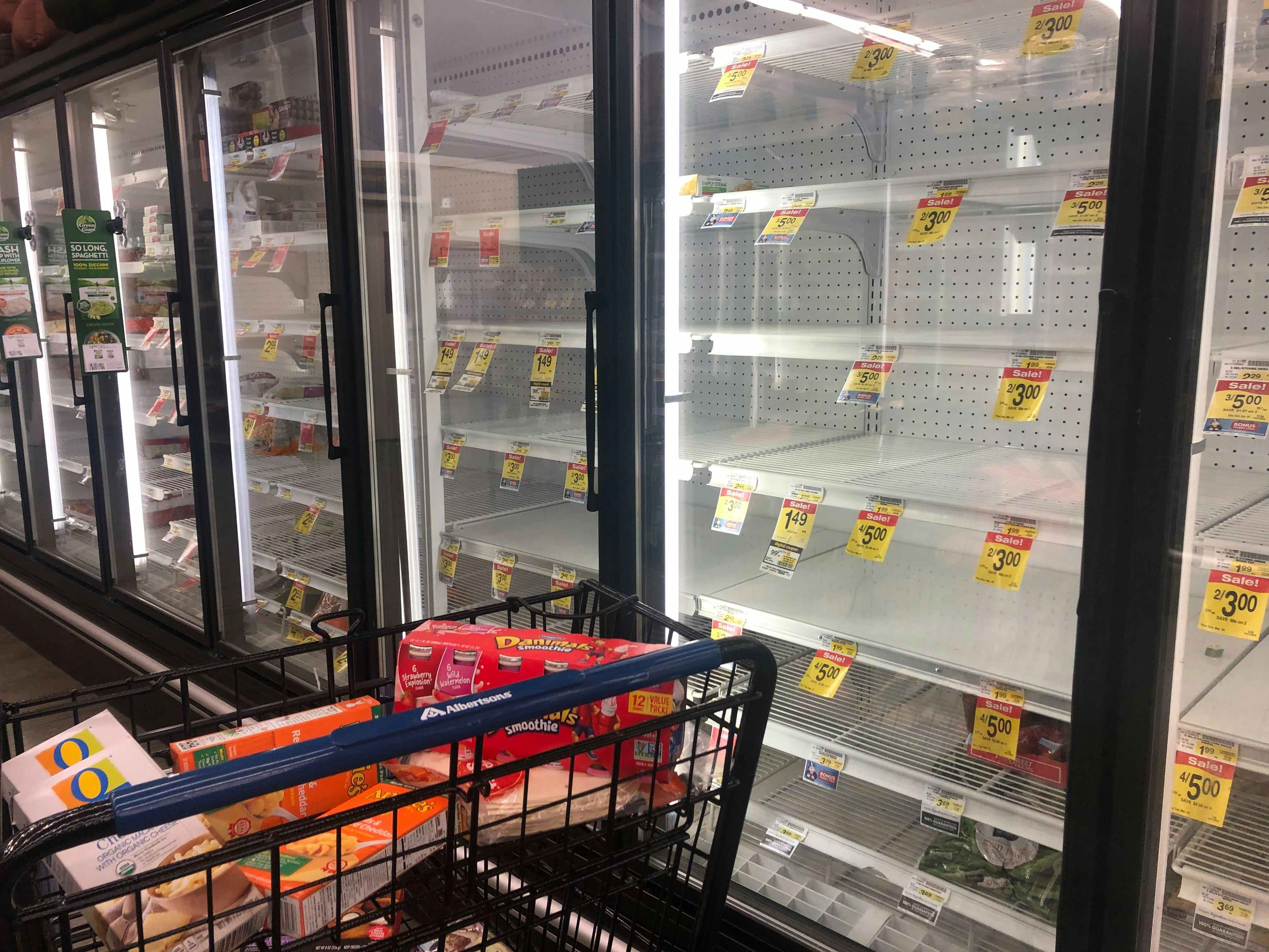 Empty frozen food coolers inside a grocery store.