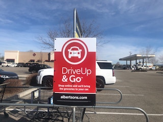A drive up and go sign outside a store.