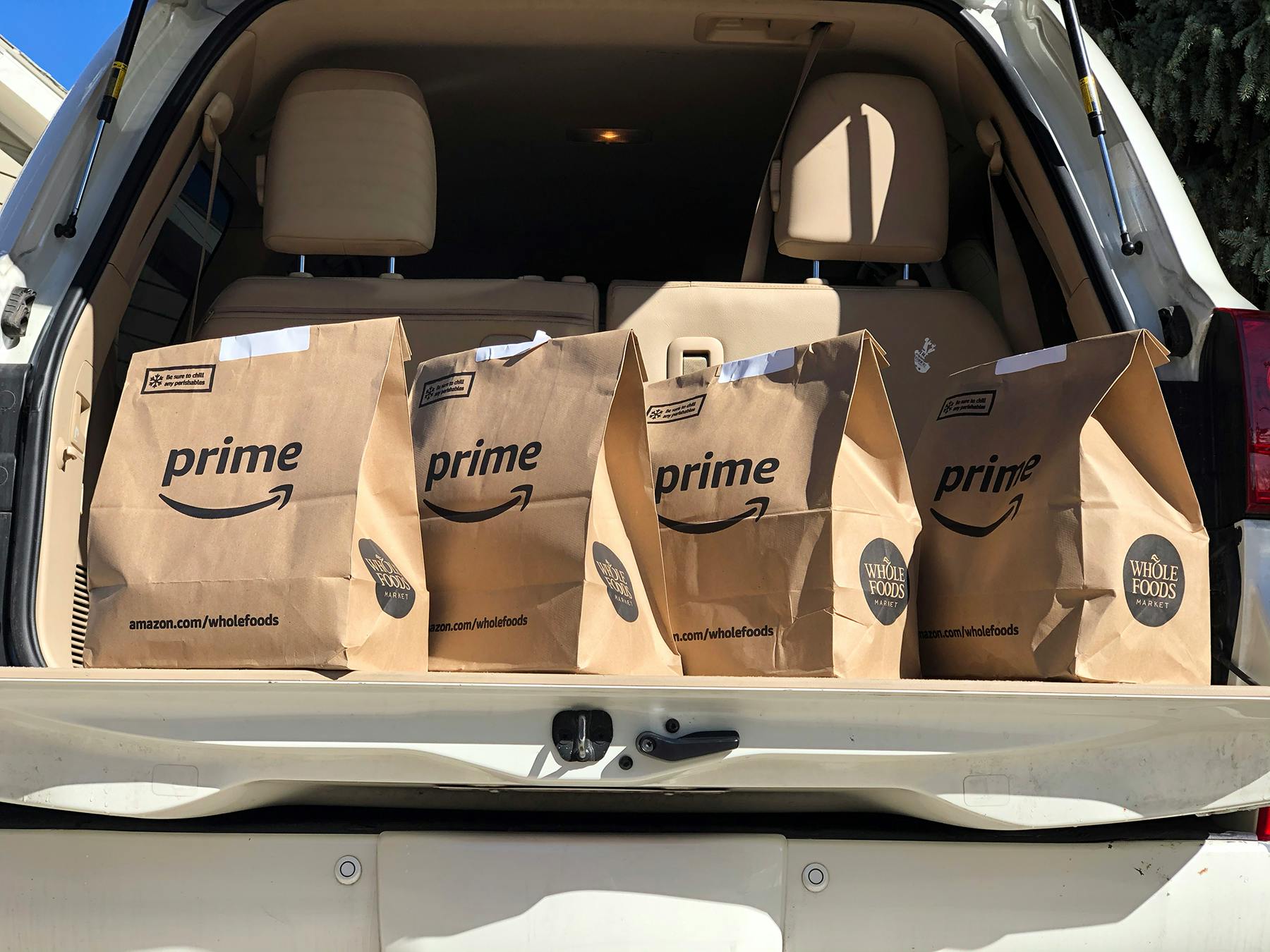Amazon Prime Now grocery bags in the trunk of a vehicle.