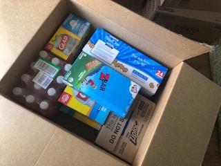An amazon box filled with home products and snack foods.