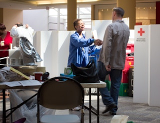 A person shaking the hand of someone wearing scrubs at the American Red Cross