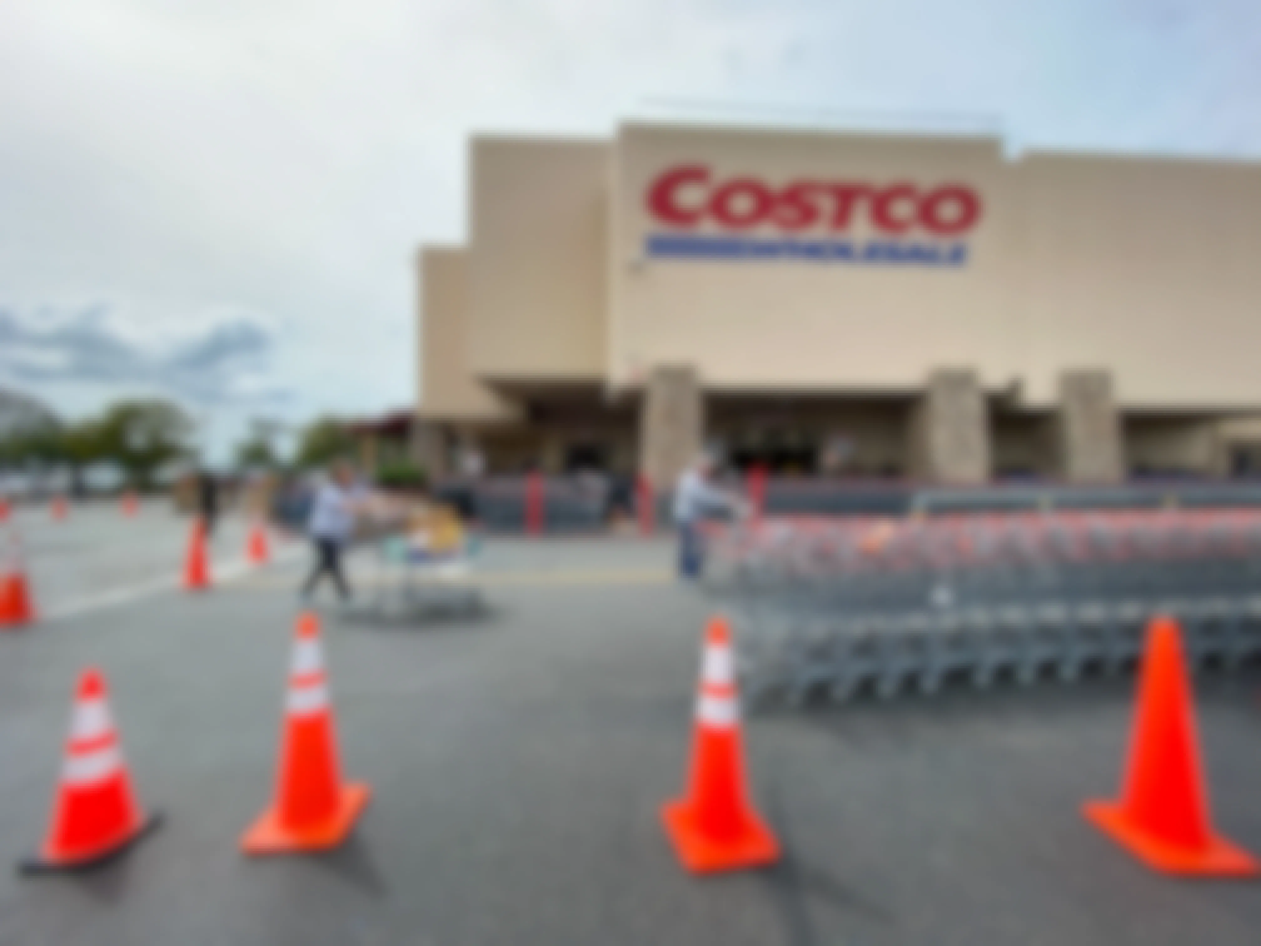 Costco store front with carts and orange cones lines up to create a new line in front of the store