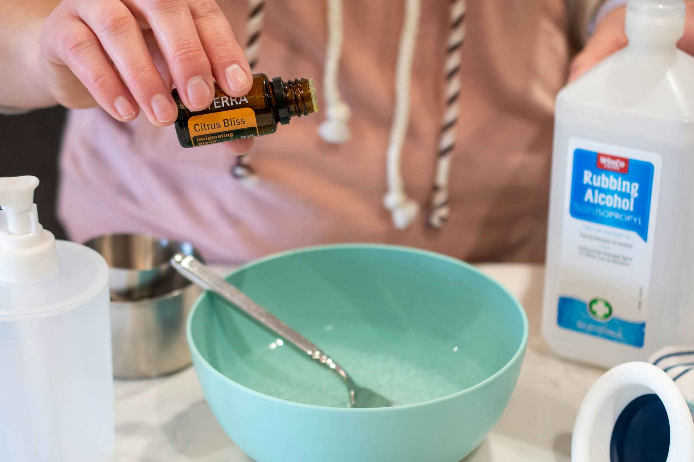 woman learning how to make hand sanitizer with essential oils