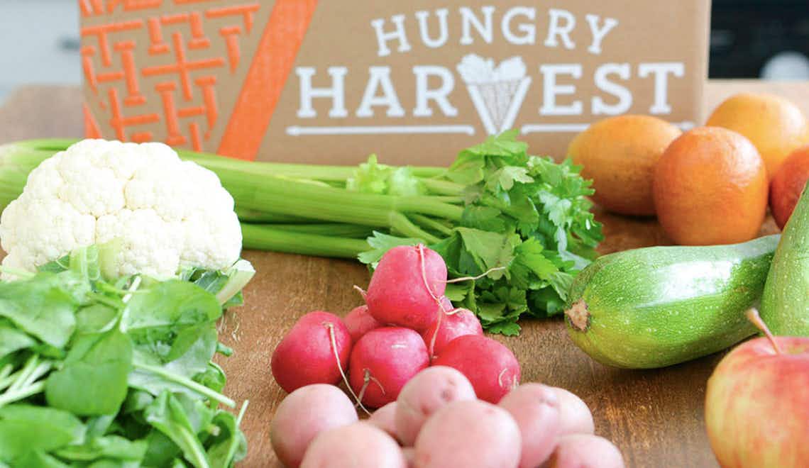 Hungry Harvest box with celery, cauliflower, squash, radish, and other produce on a table.