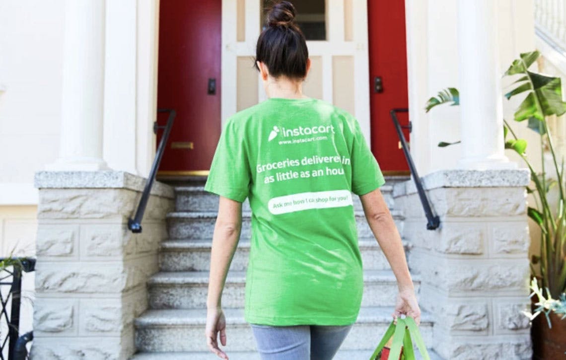 Instacart delivery person walking up to a home to deliver an order.