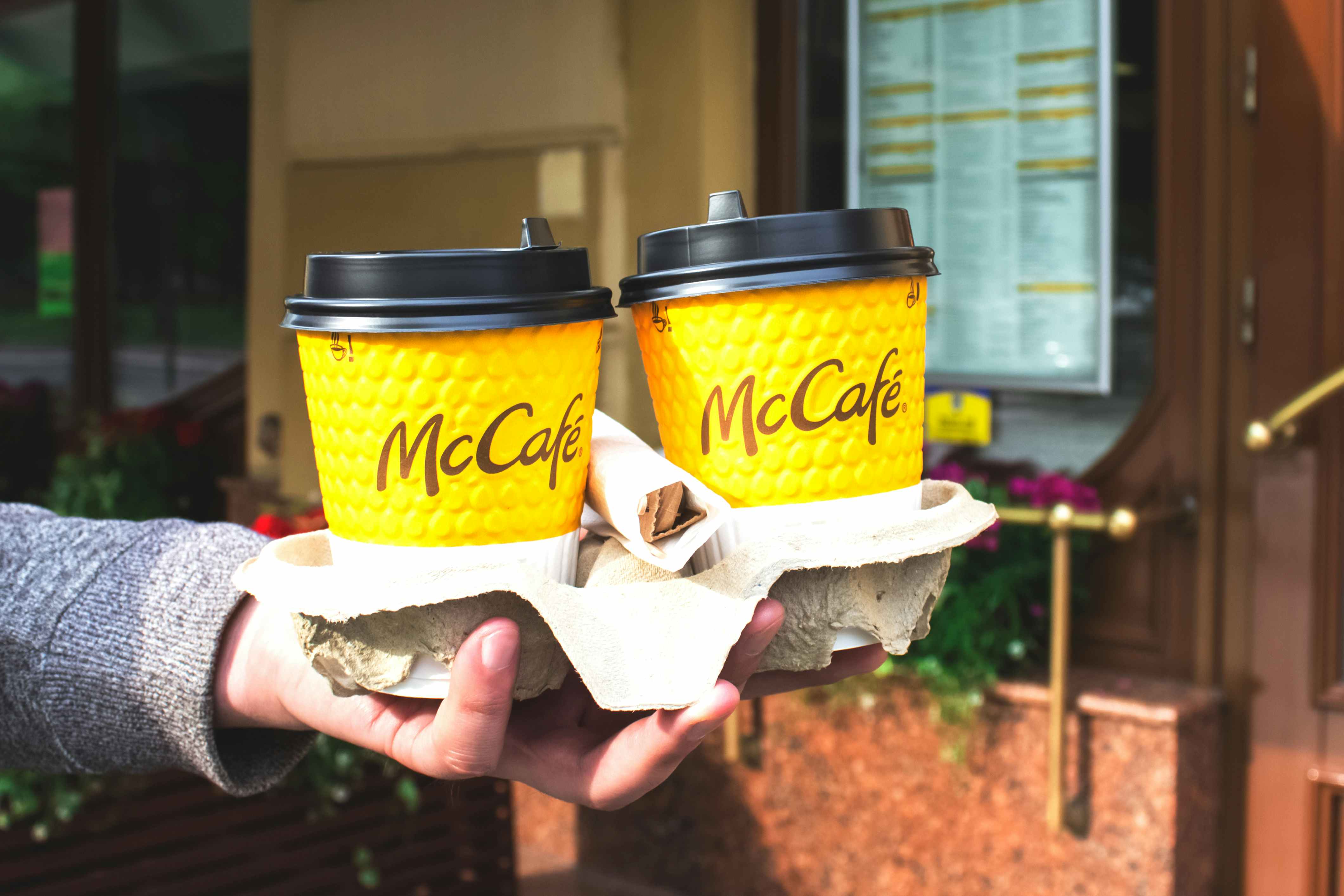 hand holding mcdonalds mccafe coffee in carrier