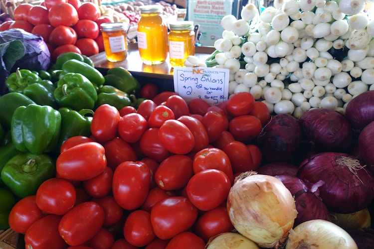 Tomatoes, onions, bell pepper, honey at a local farmers market.