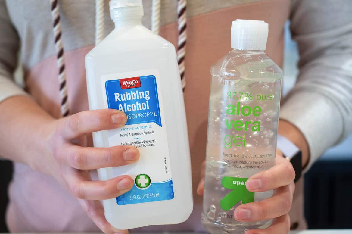 woman holding bottles of rubbing alcohol and aloe vera gel 