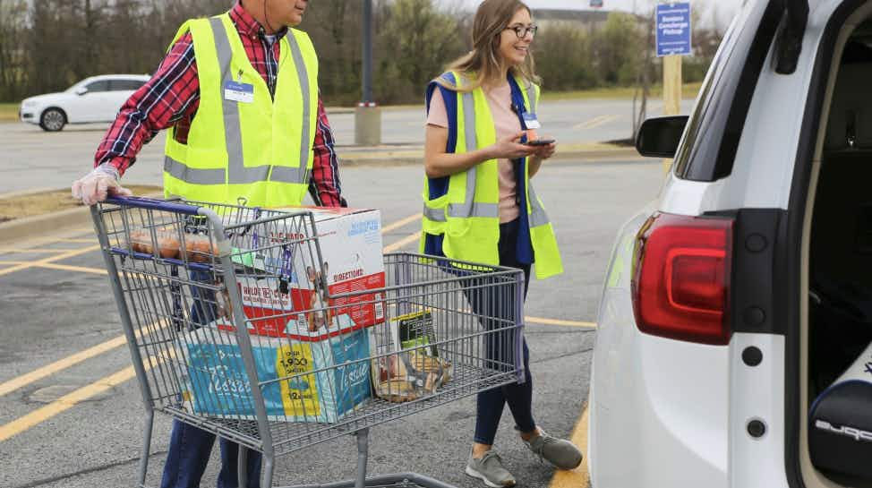 Walmart grocery pickup employees greeting a shopper.