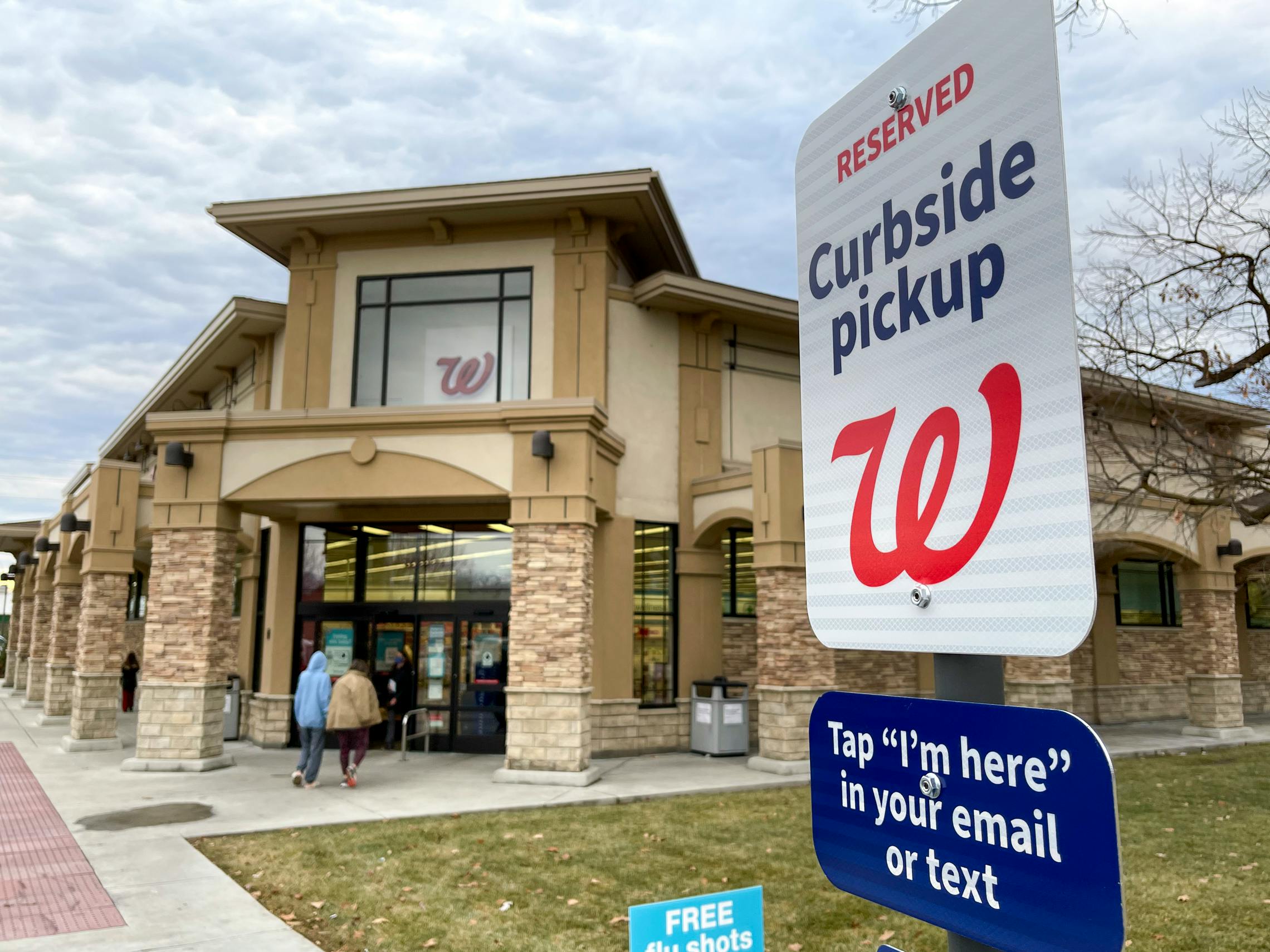 A curbside pickup sign in front of Walgreens.